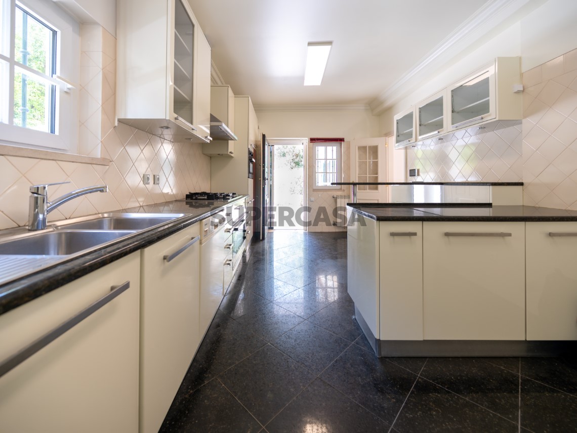 Cozinha funcional com bastante arrumação e acesso direto ao exterior, Moradia T4 + 1 | Cascais