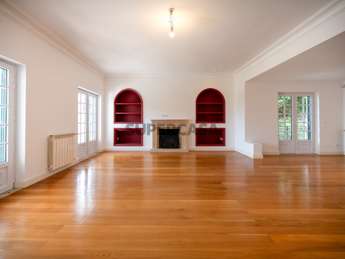 Sala com lareira central e estantes embutidas de destaque, Moradia T4 + 1 | Cascais