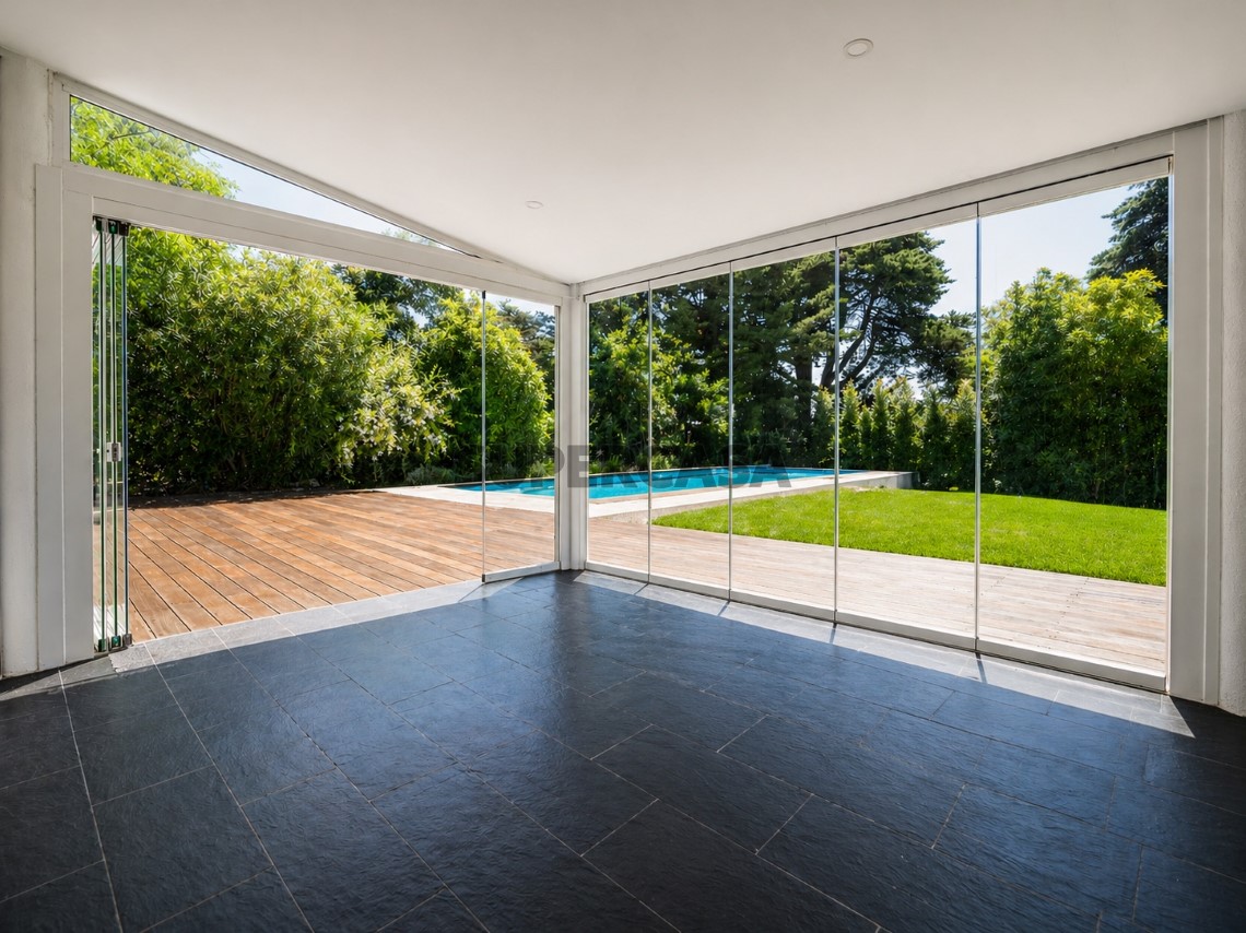 Sala ampla com paredes envidraçadas e ligação direta ao jardim, Moradia T4 + 1 | Cascais