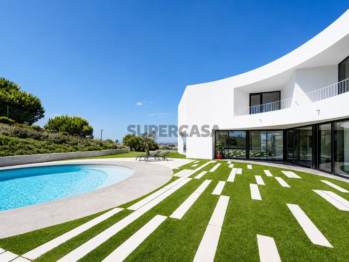 Jardín con piscina y acceso al interior de la villa en Oeiras