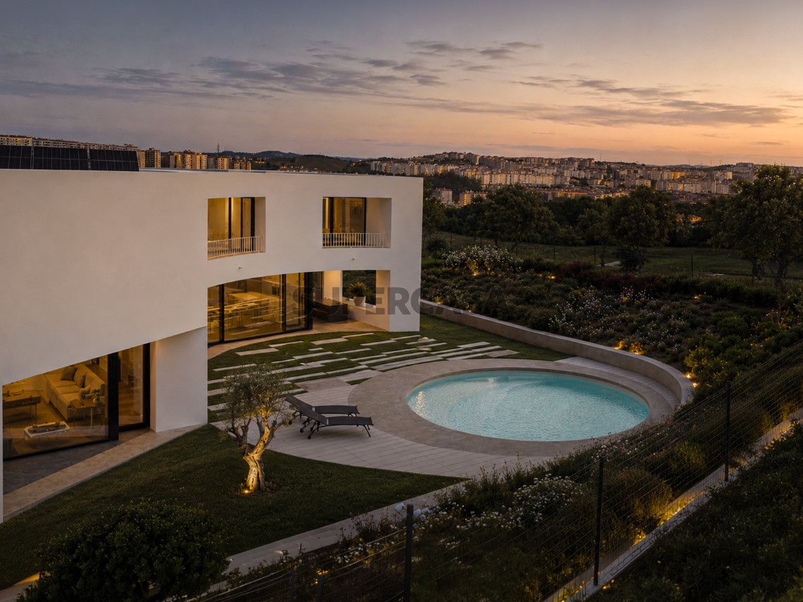 Atardecer con las luces encendidas y vistas a la piscina, la villa y Oeiras