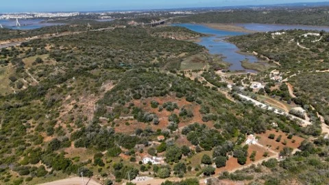 Vista aérea de grande terreno rústico à venda em Estômbar, Algarve, próximo ao rio. Oportunidade de investimento com a Spy Ma...