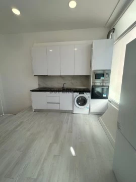 Cozinha com placa vitrocerâmica, forno, microondas, exaustor, termoacumulador, máquina de lavar roupa