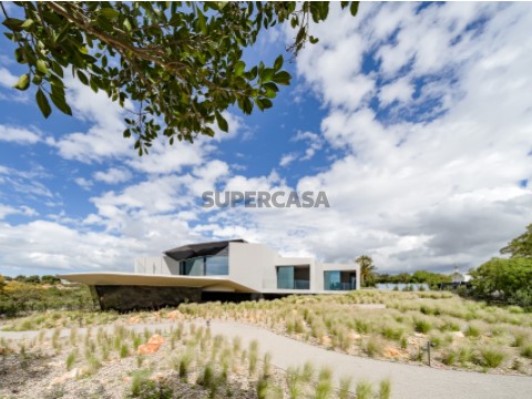 Moradia Sky Base One em Carvoeiro integrada na natureza, mostrando o design moderno das suites com acesso direto ao jardim e ...