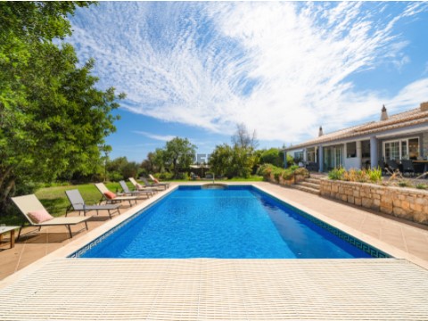 Piscina privada e casa principal de uma Quinta algarvia renovada em Lagoa. Piscina rodeada por jardins ajardinados e espregui...